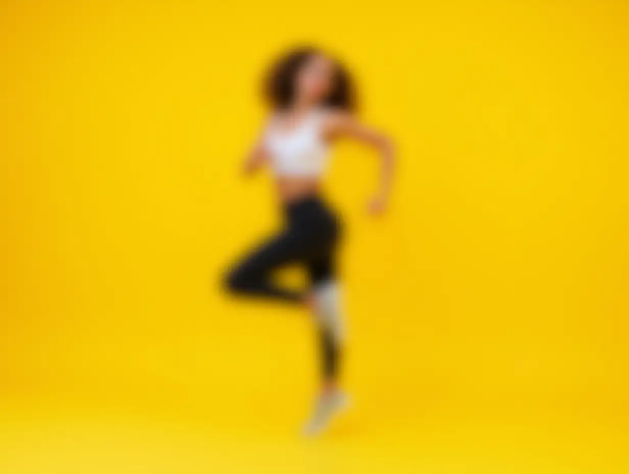 Cardio Workout. Sporty Young Lady Jumping Exercising In Studio Over Yellow Background. Selective Focus