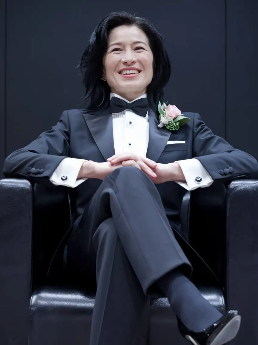 Elegant-Chinese-Woman-in-Tuxedo-Smiling-in-a-Dark-Room