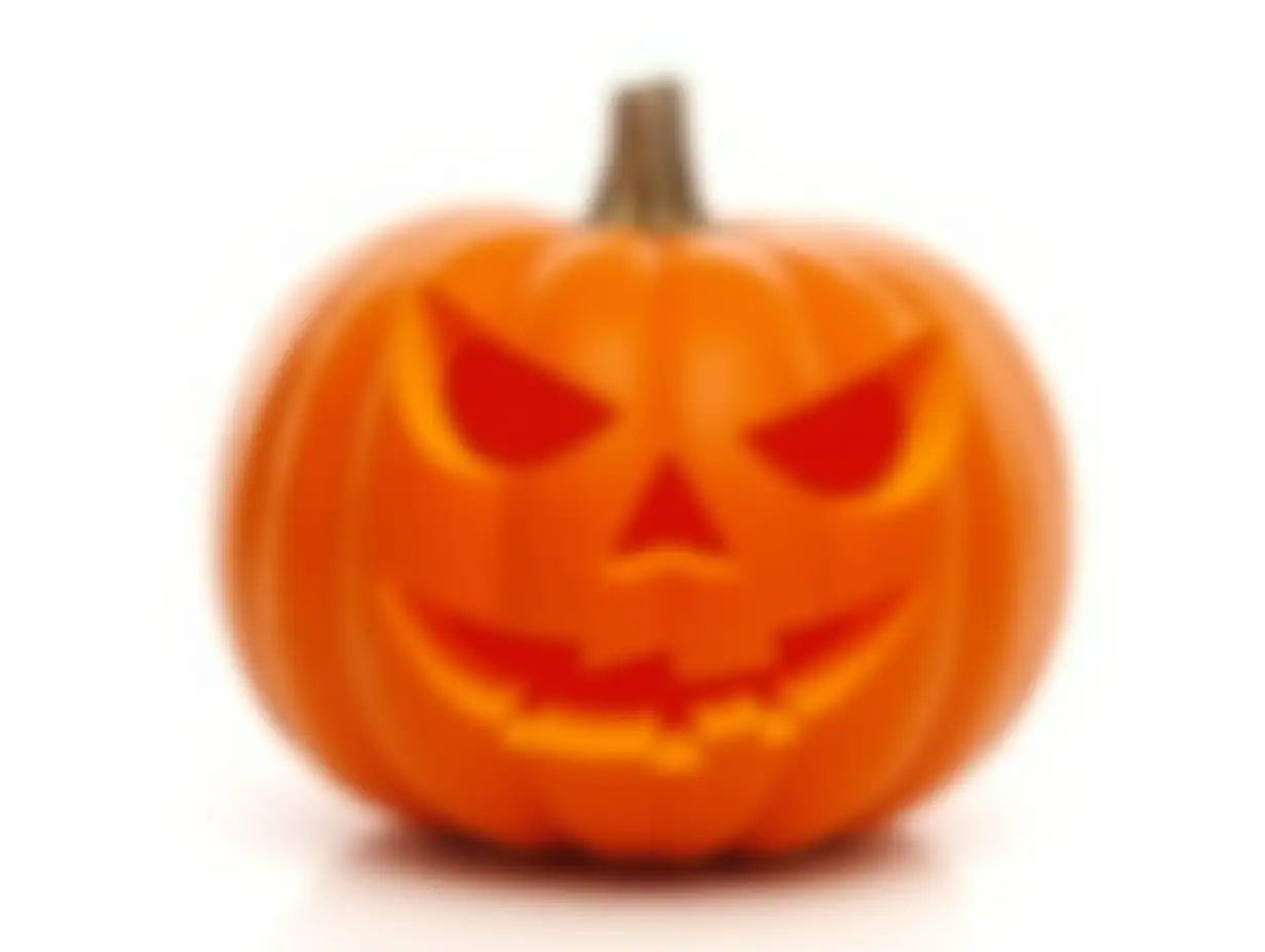 A carved halloween pumpkin with evil eyes and face isolated on white.