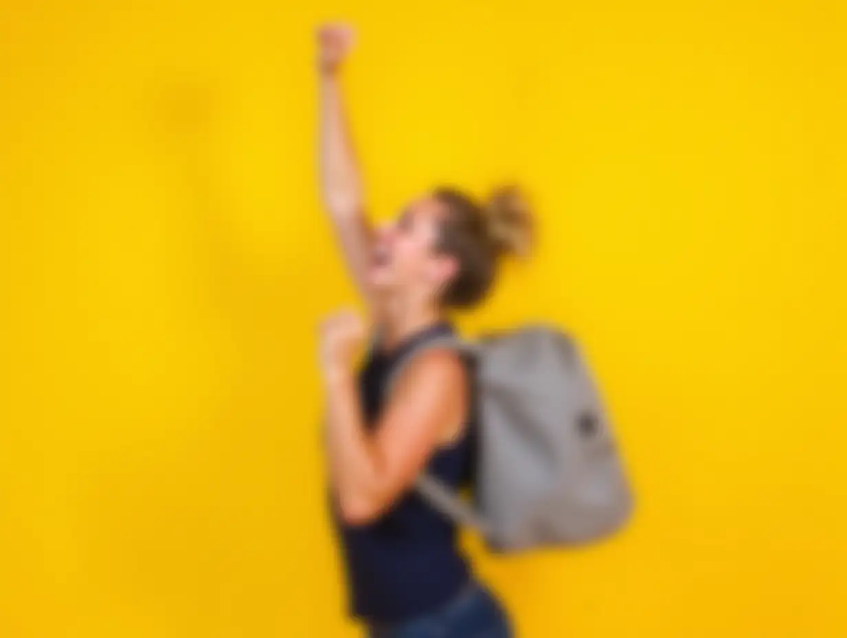 Sport-Woman-Celebrating-Victory-with-Sport-Bag-on-Yellow-Background