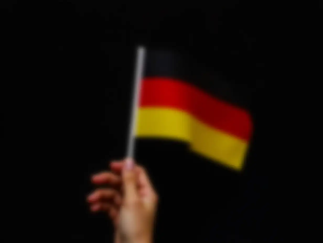 Hand is holding German flag on black background