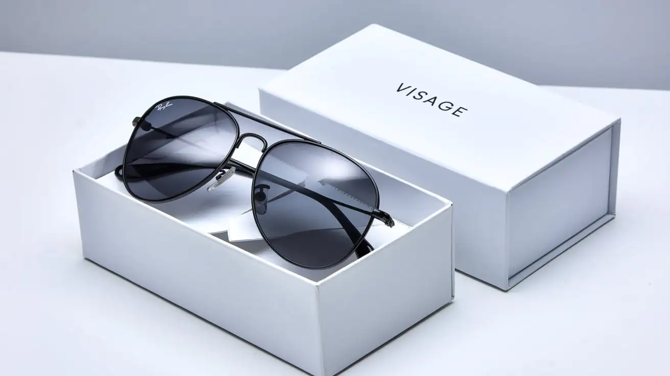 A product style image, pair of sleek aviators sitting in an all white box facing the camera with Visage written on it.