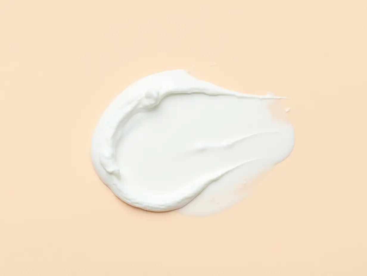 creamy smear of white cosmetic texture on beige background skin care concept