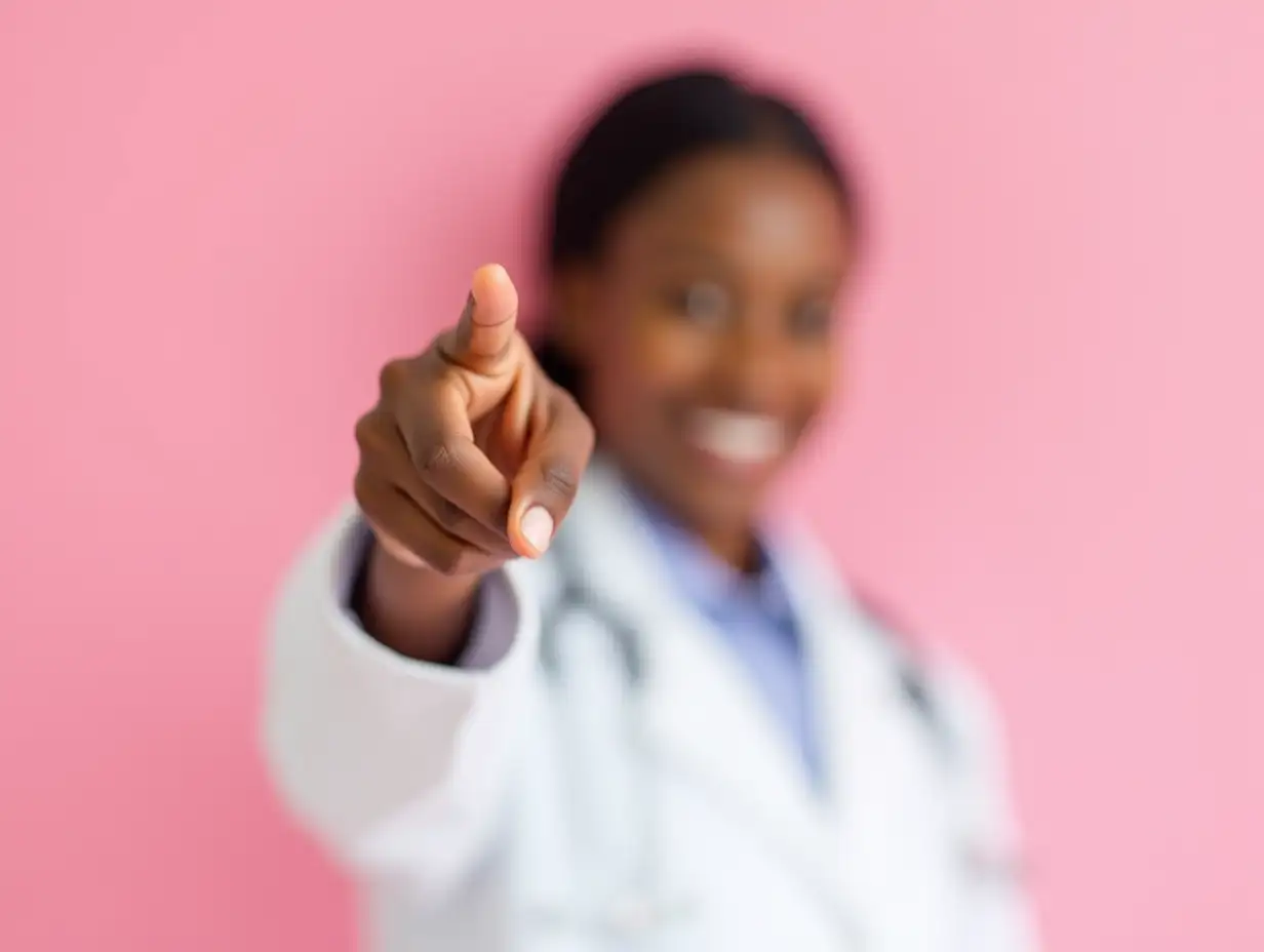 Young african american doctor woman holding cancer ribbon over isolated pink background pointing with finger to the camera and to you, hand sign, positive and confident gesture from the front